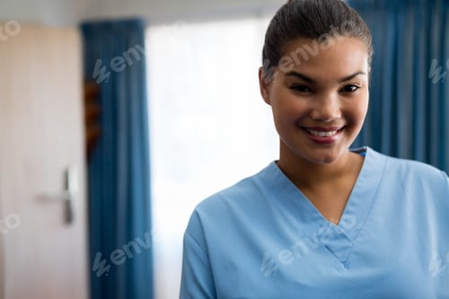 Preview: Female nurse standing in clinic wearing blue scrubs near frosted window, copy space