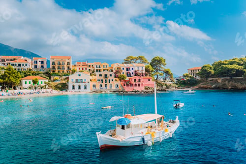 Preview: View of beautiful bay of Assos village with fishing boat at anchor in front and clouds in background