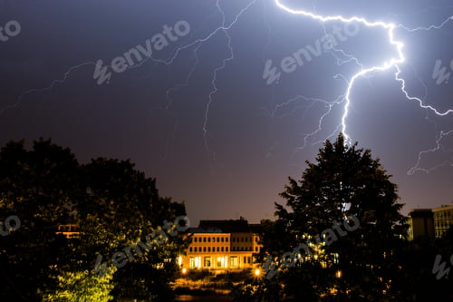 Preview: Lightning during the evening in a neighborhood surrounded by greenery and buildings