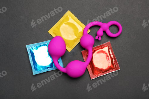 Preview: Anal balls and condoms on black background, top view. Sex game