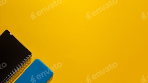 Preview: Top view of a smartphone and a notepad on a yellow background