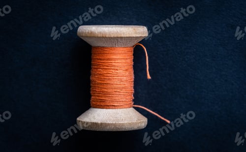 Preview: Orange thread on wooden bobbin