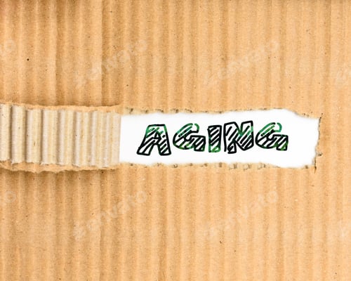 Preview: Aging is the process of becoming older, Ageing word written on crumpled and torn paper.