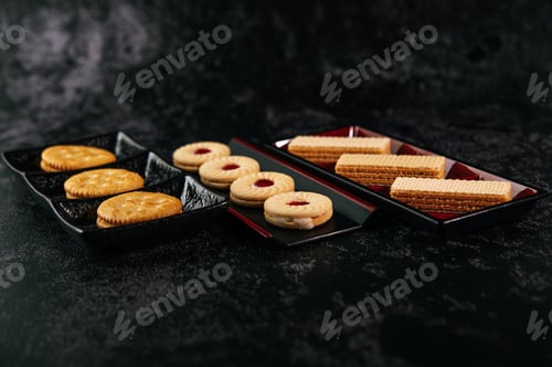 Preview: Many cookies are beautifully arranged in a plate and then placed on a wooden table.