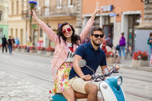 Preview: young beautiful hipster couple riding on motorbike city street
