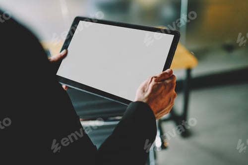 Preview: Faceless man using tablet at workplace