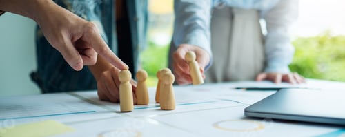 Preview: Business team brainstorming and planning strategy together withwooden people in a meeting