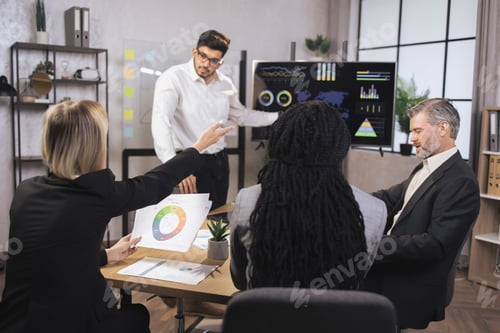Preview: Blonde businesswoman holding out hand to ask a question.