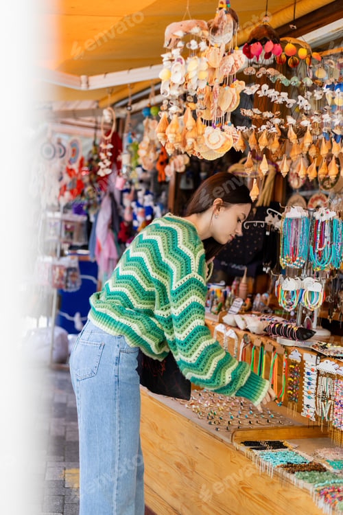 Preview: Side view of young woman choosing accessories on flea market in Turkey