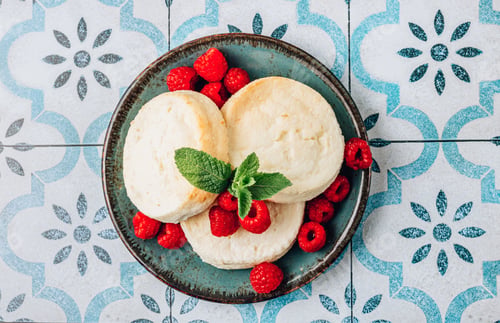 Preview: Mini cheesecakes with raspberries on a tiled background