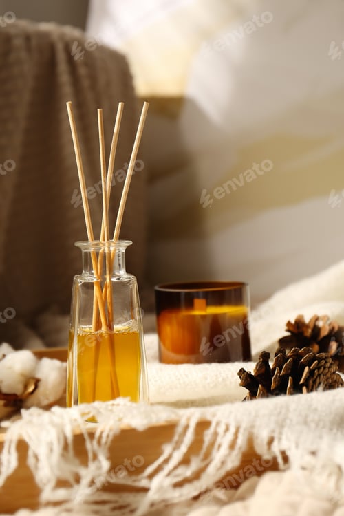 Preview: Reed air freshener, candle and pine cones on wooden tray indoors