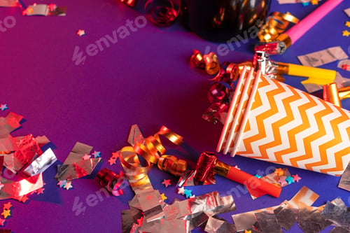 Preview: Party tinsel and colorful cups close up on purple background
