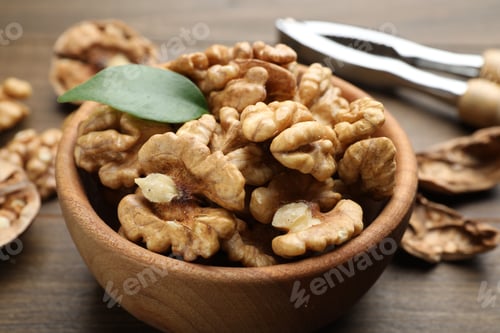 Preview: Peeled walnuts in bowl on table, closeup