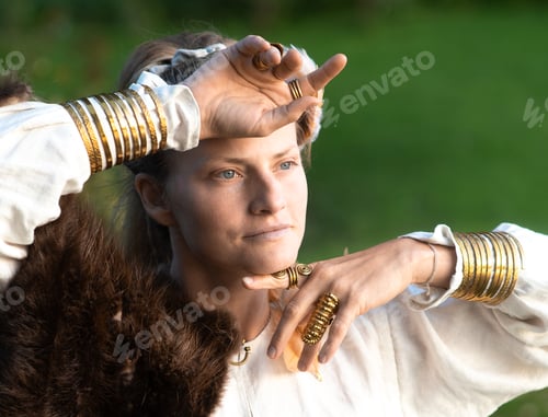Preview: Harmonious calm woman with fur, feather ornaments, gilded copper rings and bracelets