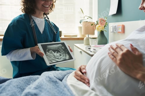Preview: Caucasian Pregnant Woman Receiving Ultrasound Scan from Female Medical Professional