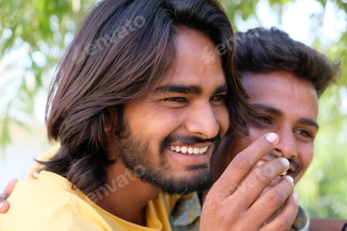 Preview: Portrait of an excited Indian gay couple embracing and smiling in a park
