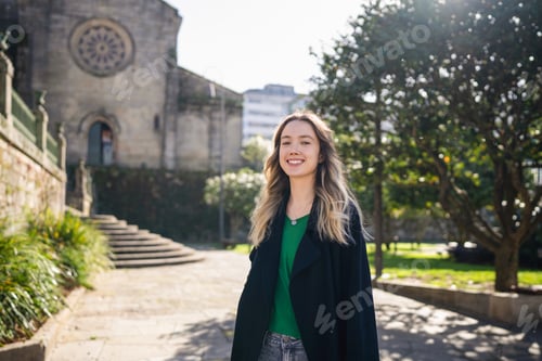 Preview: Young woman smiling outdoors in a historic city