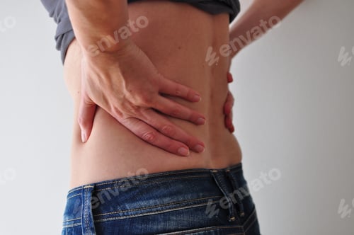 Preview: Woman holding her hips – probably because of pain