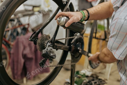 Preview: Close up of repairman is lubricate the bike chain in workshop. High quality photo