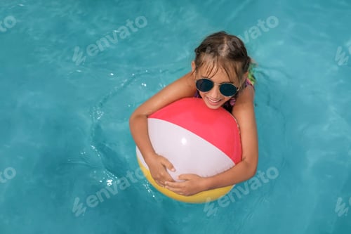 Preview: Laughing girl in blue sunglasses swims hugging an inflatable ball for pool.