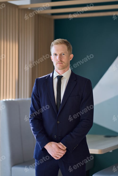 Preview: Confident young professional business man standing in office. Vertical portrait.