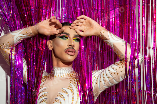 Preview: portrait of beautiful young man in drag queen makeup and colorful background