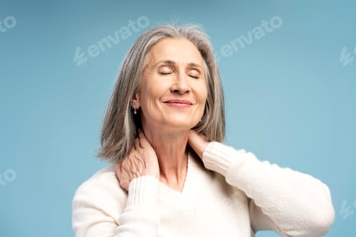 Preview: Portrait of smiling, elderly senior woman touching neck, having pain, mature female relaxing