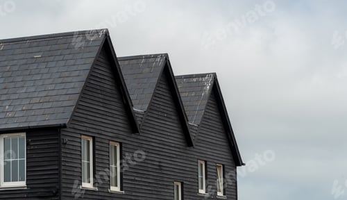 Preview: Wooden house roof attics against cloudy sky. Home residential building