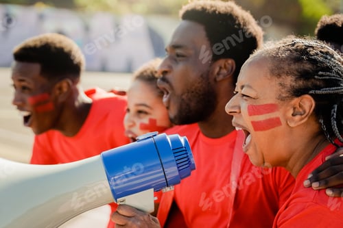 Preview: African red sport football fans celebrating team victory in soccer championship game at stadium crow
