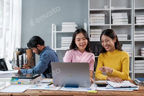 Preview: Group of young Asian business people brainstorming, looking at laptop computer.