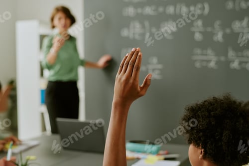 Preview: Black Child Raising Hand While Listening to Teacher Explaining Lesson