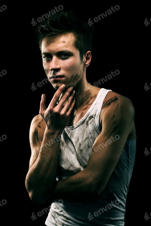 Preview: Young athletic man with dirty spots on body pitting black paint to his face