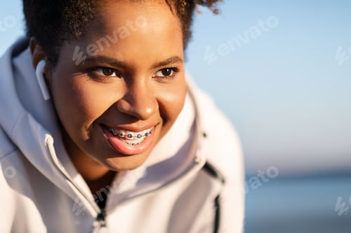 Preview: Closeup Portrait Of Smiling Young Black Female Athlete Resting Outdoors After Training