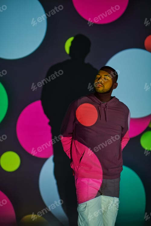 Preview: trendy african american male model with closed eyes in digital projector lights, fashion concept