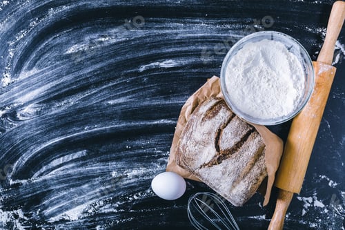 Preview: Baking bread using flour, egg, and tools on a dark countertop