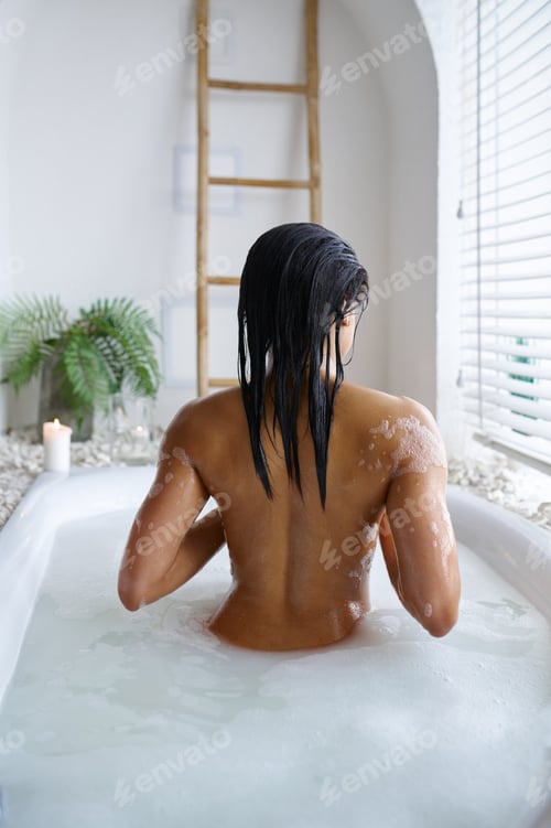 Preview: Attractive woman relax in a bubble bath, back view