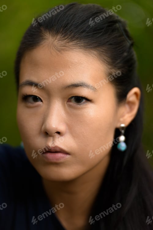 Preview: Close-up portrait of beautiful rebel Asian woman face outdoors