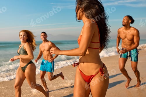 Preview: Couple With Friends In Swimwear On Vacation Running Along Beach Shoreline