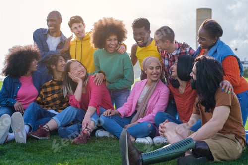 Preview: Multicultural group of friends hanging out outdoors during a sunset. Concept: diversity, lifestyle