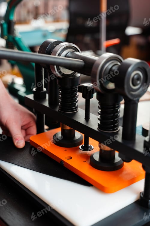 Preview: Embossing leather with machine. Artisan enhances handmade wallets, belts, and goods
