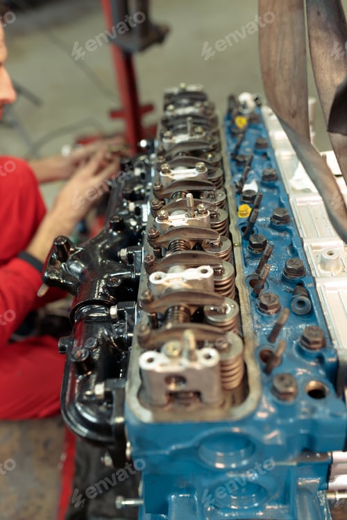 Preview: Vertical closeup shot of a mechanic mounting the car engine