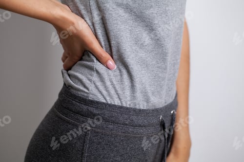 Preview: Young woman touching loin suffering from pain
