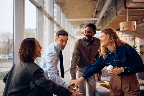Preview: Cheerful diverse colleagues celebrating their business success in the office.