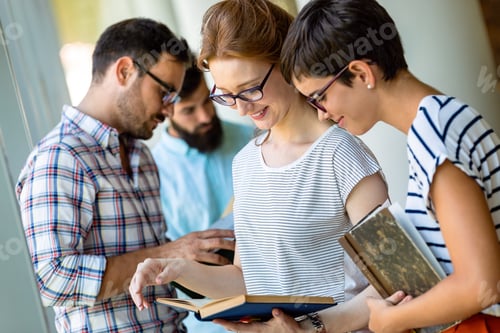 Preview: Happy university students studying with books in library. Group of multiracial people in college