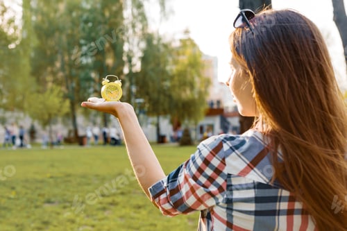 Preview: Young Woman Holding a Clock in the Park