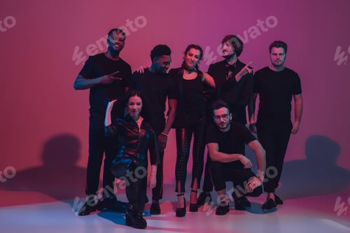 Preview: Group of young multiethnic musicians created band, dancing in neon light on pink background