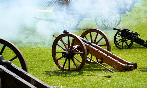Preview: Closeup shot of fired old canons in a field surrounded with white smoke