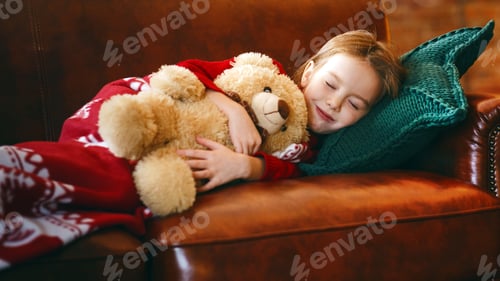 Preview: Little girl sleeping near illuminated tree dreaming about christmas miracles