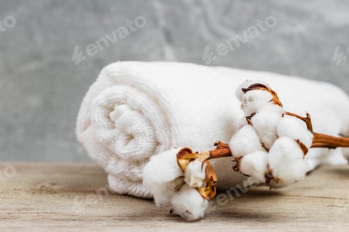 Preview: Cotton flower branch and white towel in the bathroom. Organic cotton products