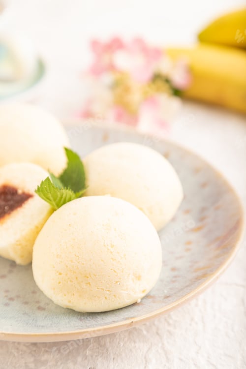 Preview: Japanese rice sweet buns mochi filled with jam on a gray concrete. side view, selective focus.